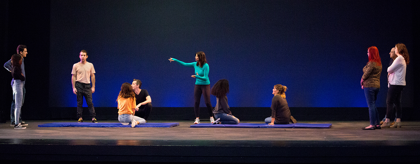 students and professor teaching theater on stage